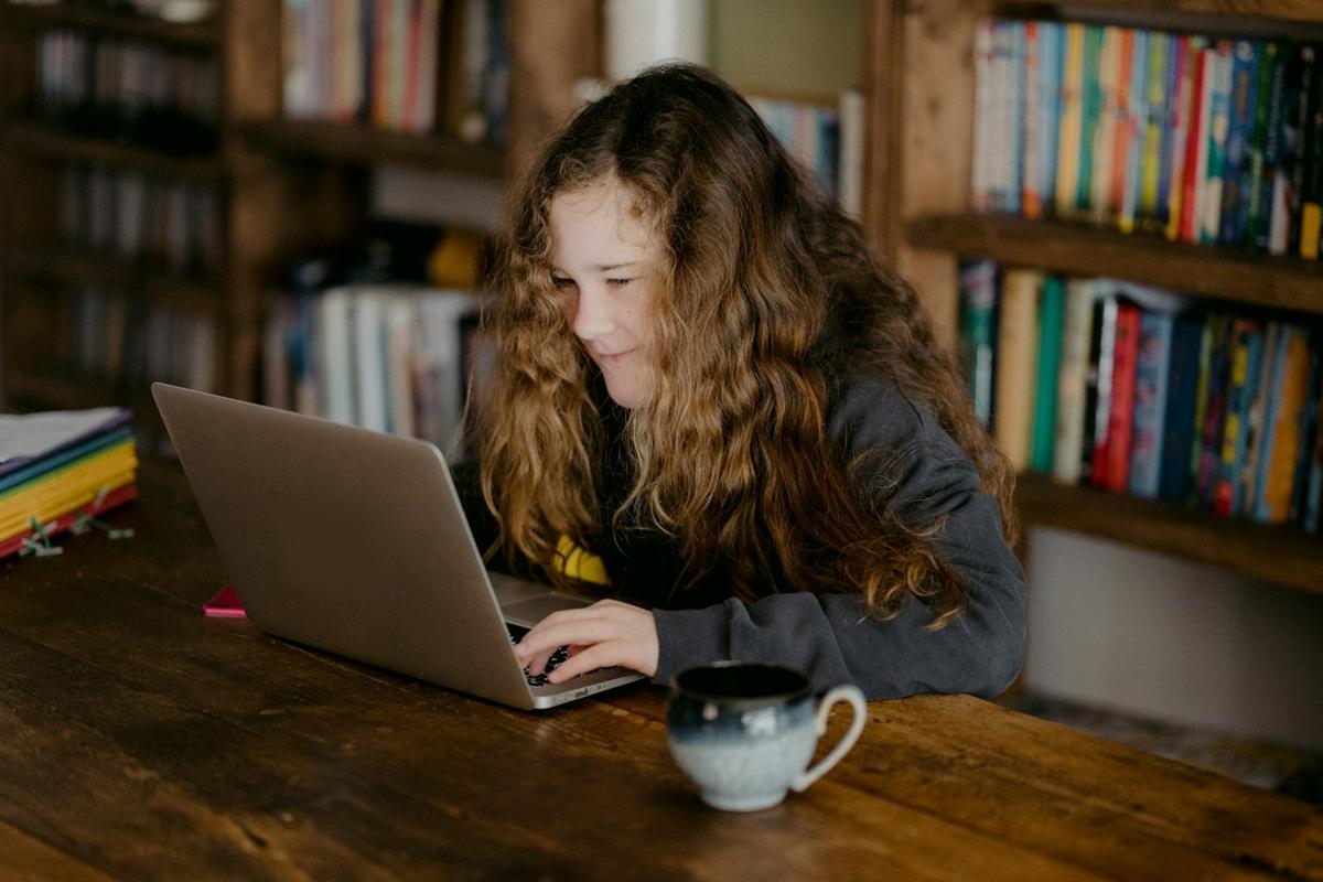 A secondary student working on her laptop at home